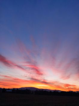 Captivating sunset sky with vibrant hues over Králíky's tranquil fields.