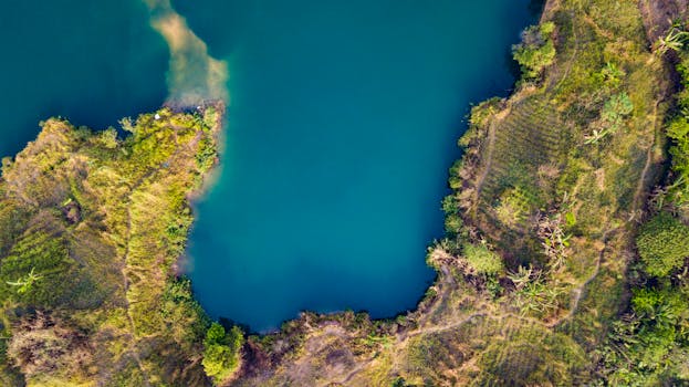Aerial shot of a vibrant lake surrounded by lush greenery in Pagedangan, Indonesia.