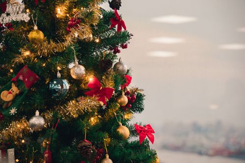Free Brightly decorated Christmas tree with colorful ornaments and twinkling lights indoors. Stock Photo