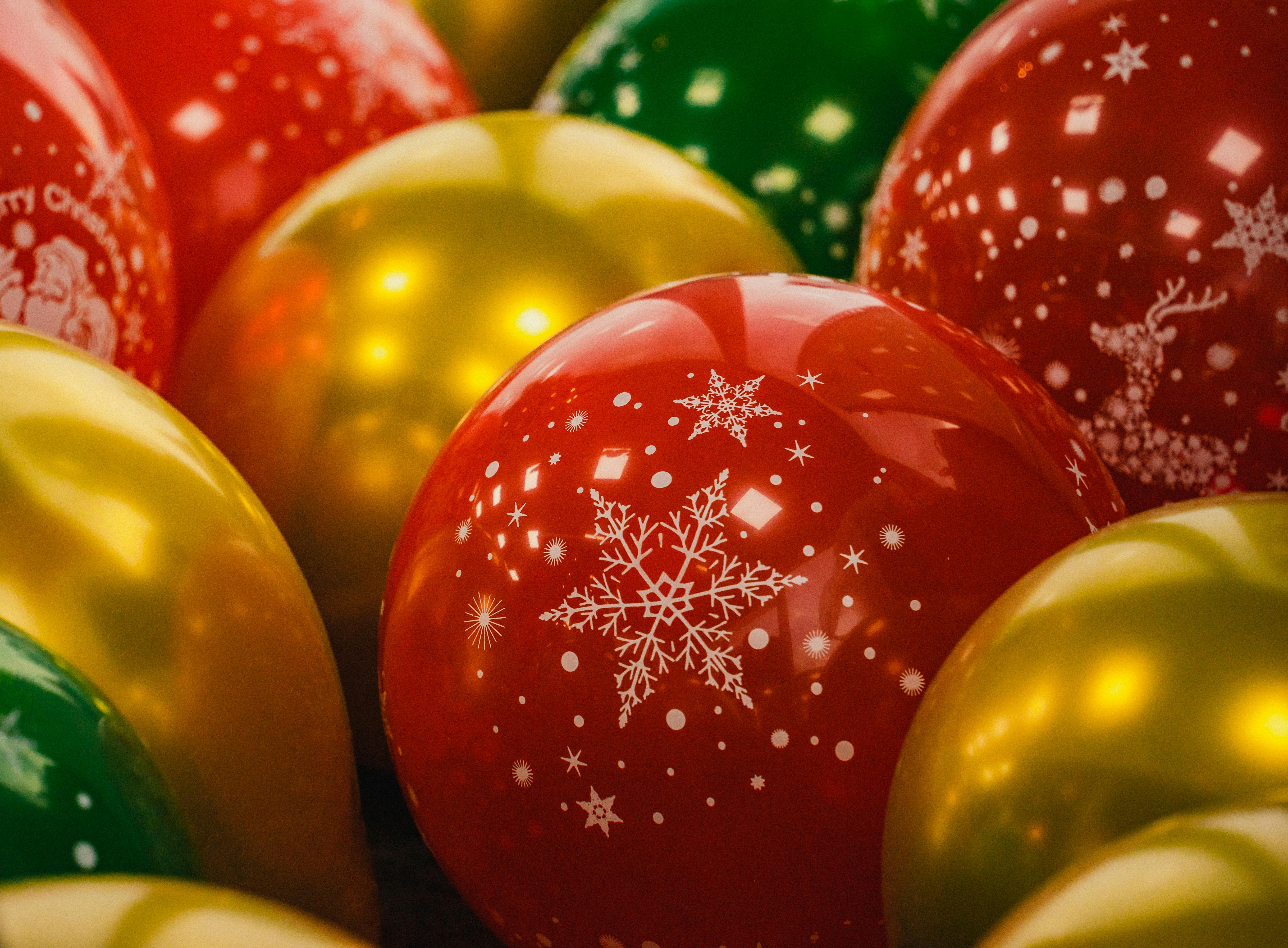 Close-up of vibrant Christmas balls featuring festive snowflake and reindeer designs.