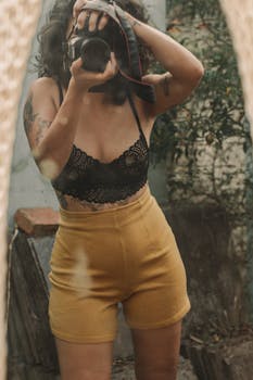 A young woman captures a self-portrait in a mirror, showcasing her artistic side.