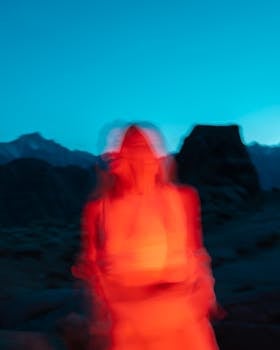A vibrant abstract photo of a blurred figure with vivid colors against a scenic nighttime backdrop.