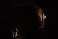 Photo of a Person in a Dark Cave with a Window