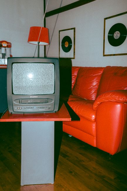 Vintage-themed room with a classic TV, red couch, and vinyl records.