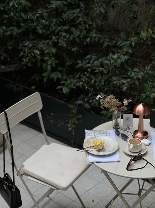 Free Elegant outdoor café setting with coffee, dessert, and chic decor. Perfect for lifestyle and travel inspiration. Stock Photo