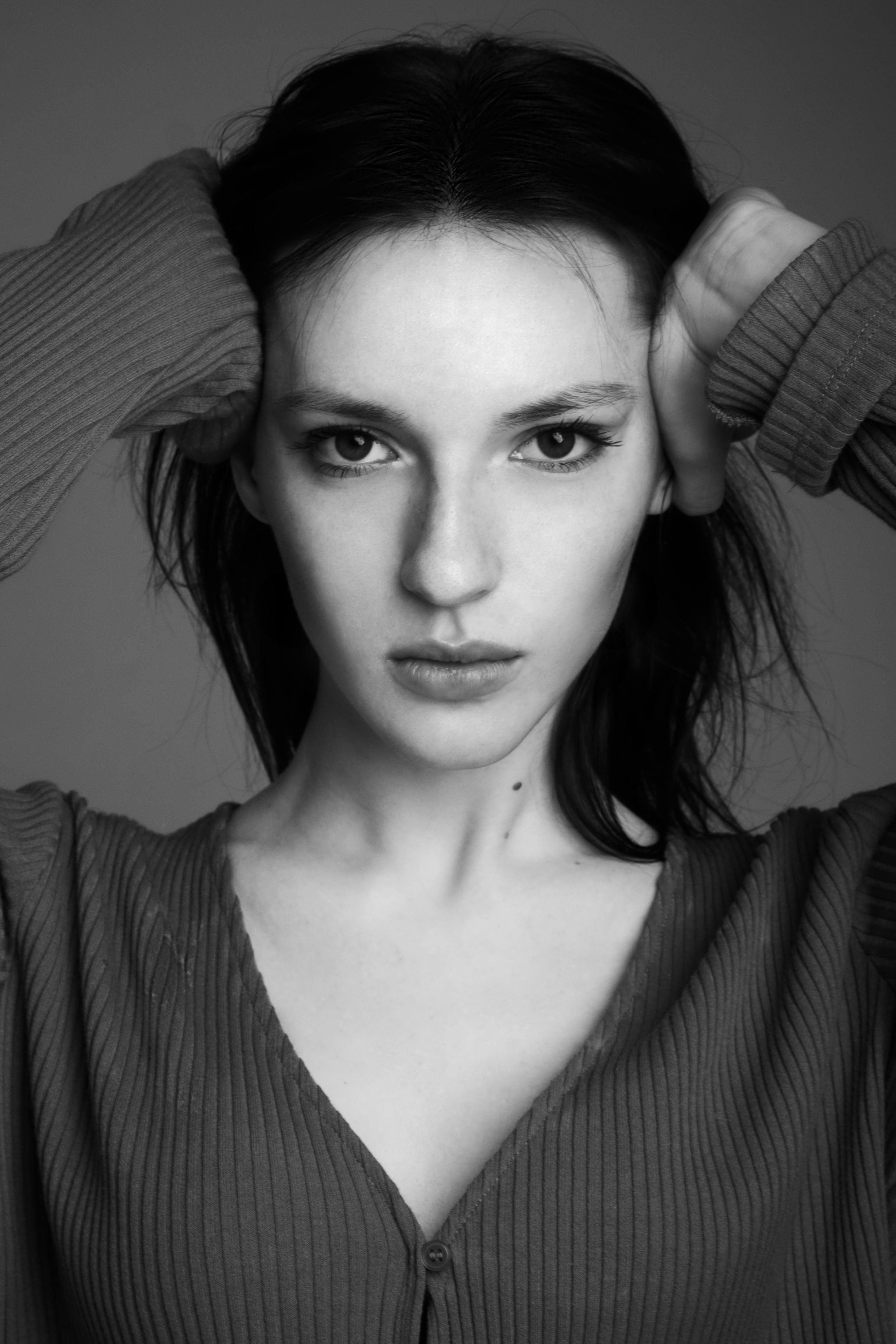 Striking black and white portrait of a woman, emphasizing elegance and poise.