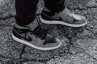 Grayscale image showcasing stylish sneakers on textured asphalt.
