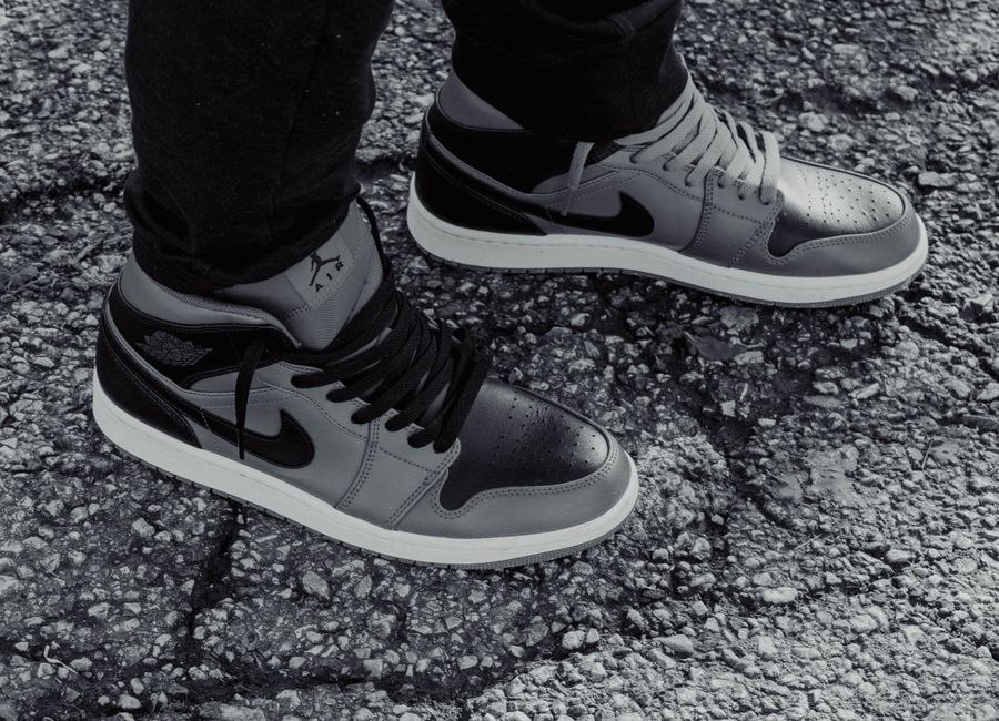 Grayscale image showcasing stylish sneakers on textured asphalt.