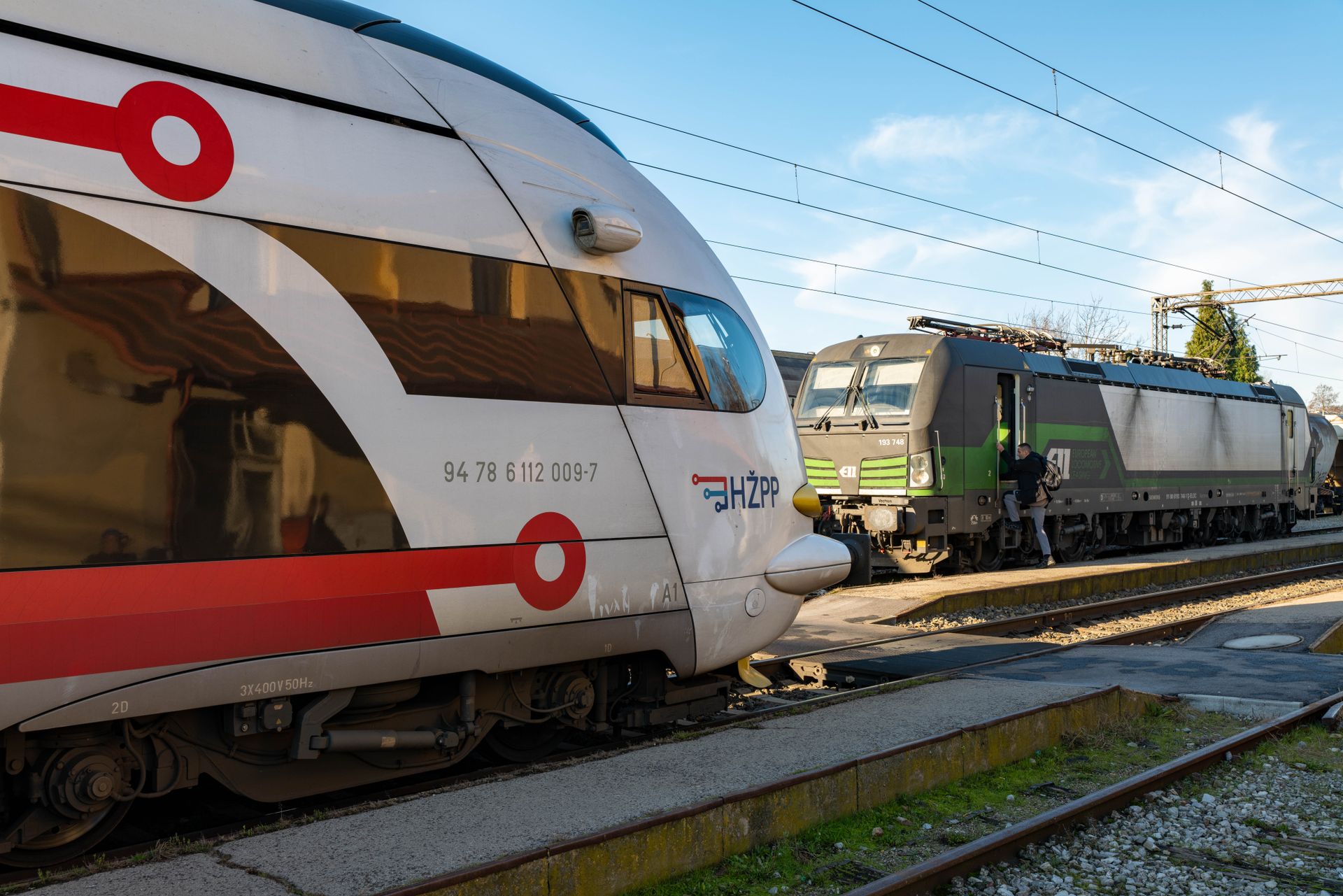 Two modern locomotives in a railway station, showcasing vibrant designs and public transportation.
