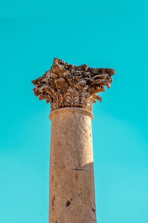 Free Close-up of a detailed ancient Roman column against a clear sky in Jerash, Jordan. Stock Photo