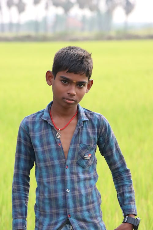 Photo of a Young Indian Boy Wearing a Blue Plaid Shirt