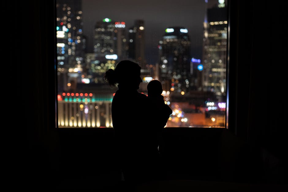 A mother and baby silhouetted against the nighttime skyline of Nashville.