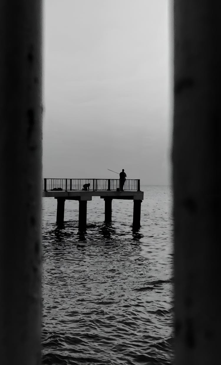 Man Fishing On A Pier 