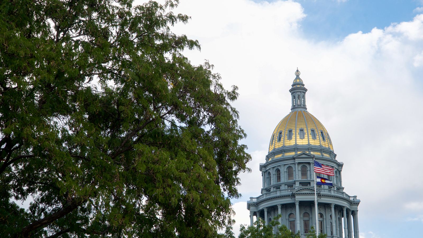 The Denver State Capitol building with its iconic gold dome under a clear blue sky.