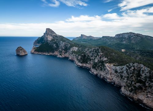 Free A captivating aerial shot of scenic cliffs meeting the vast blue ocean under a clear sky. Stock Photo