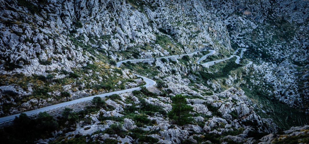 Kurvige Bergstraße führt durch eine felsige Kärntner Landschaft.