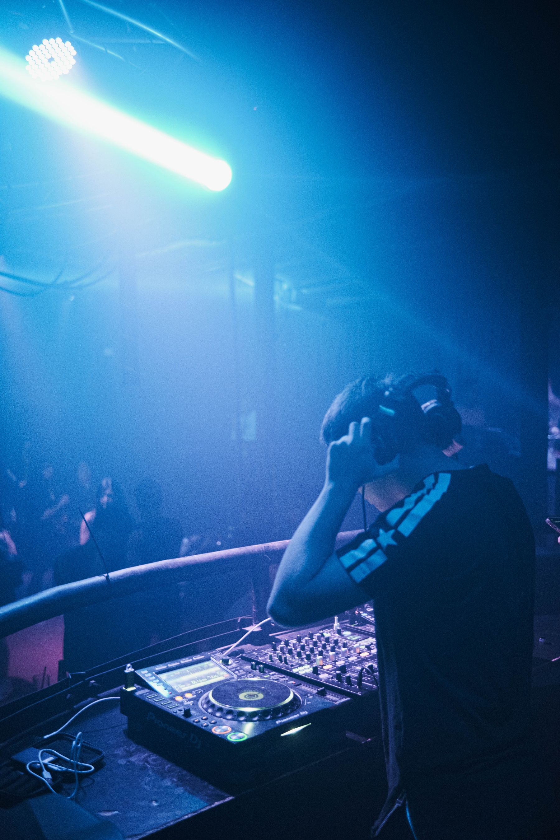 DJ performing at a mixing console in a nightclub