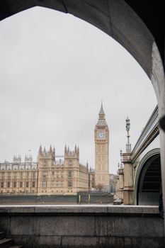 A classic view of Big Ben and Westminster Bridge in London, framed by an arch.