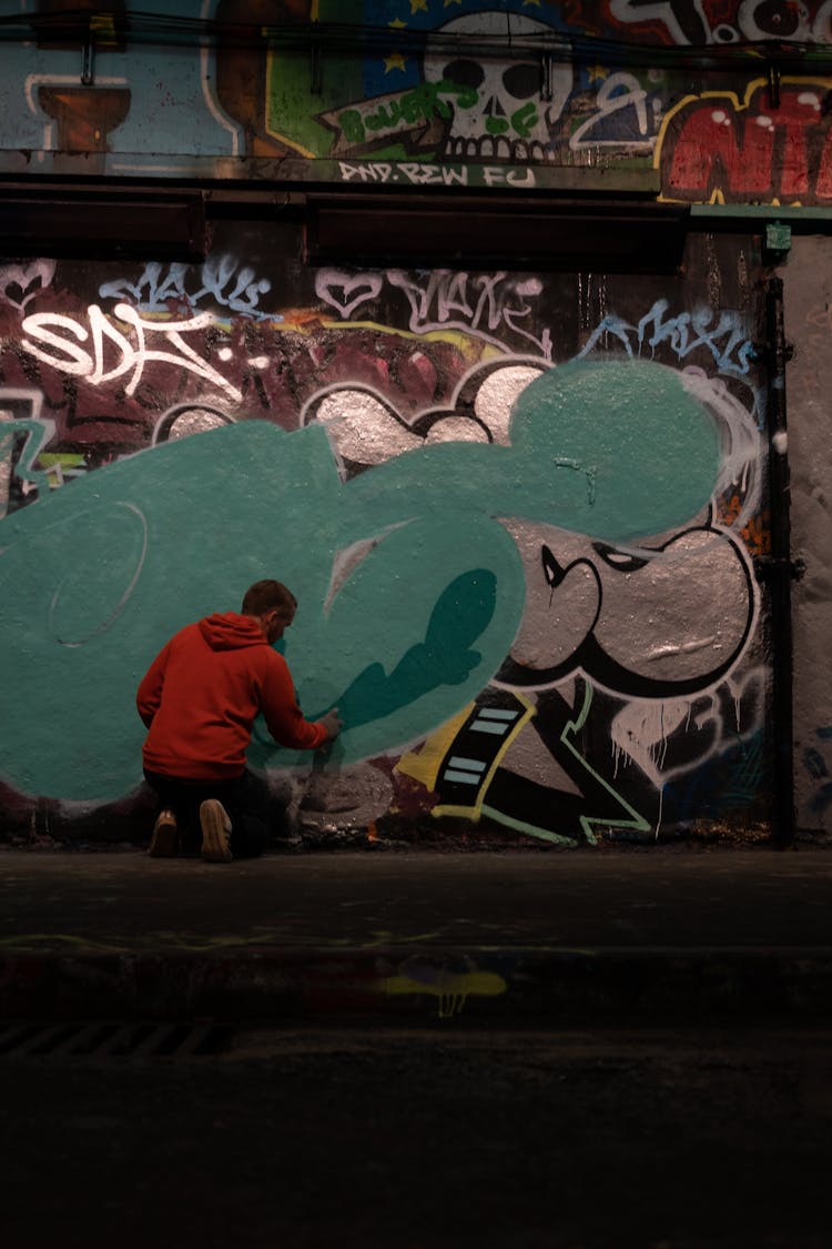 Man Drawing Graffiti On Building Wall