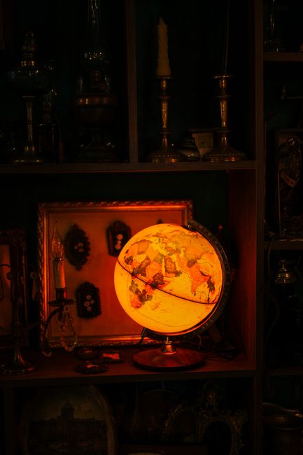 Warmly lit vintage globe in an antique room setting, perfect for interior decor themes.