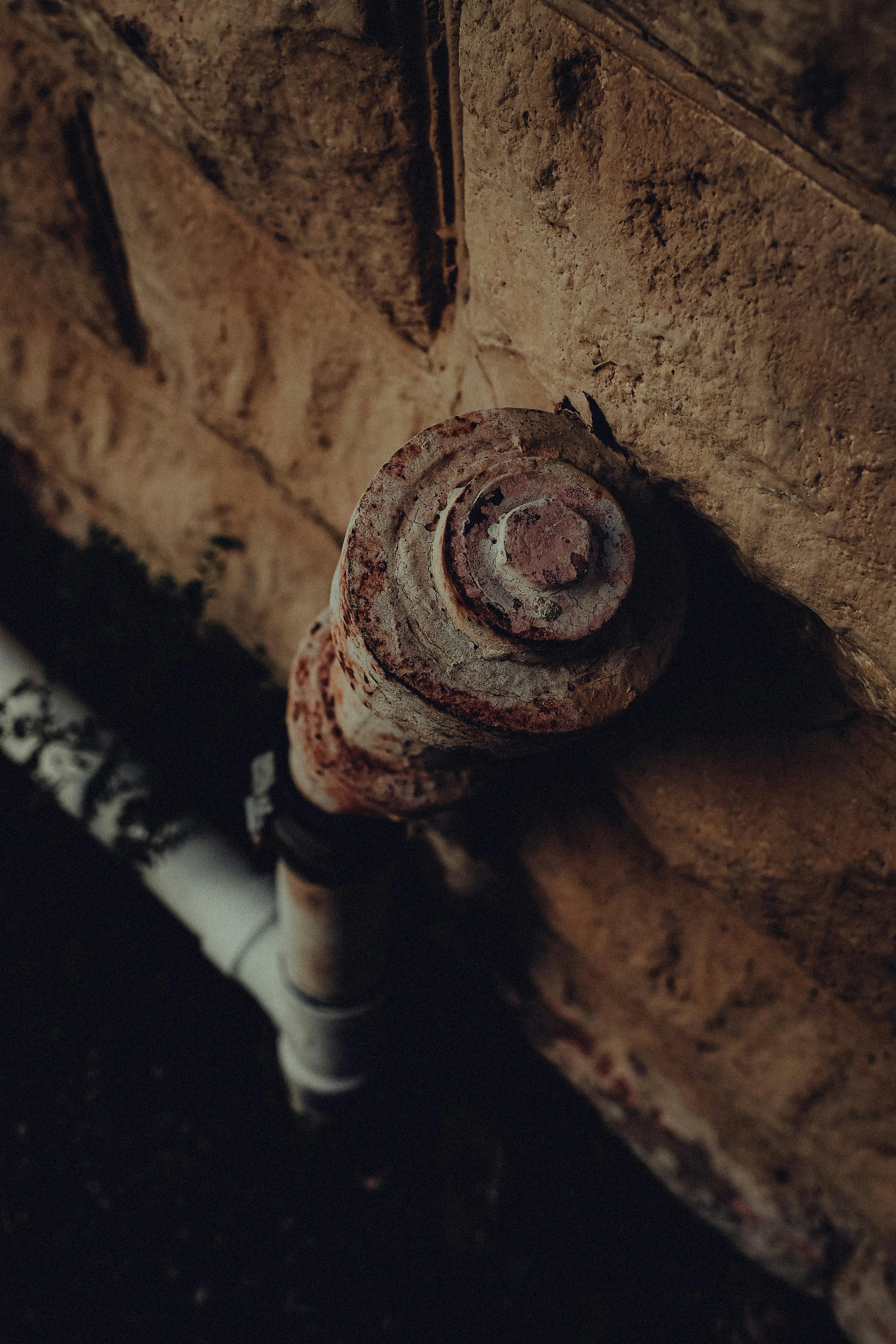 an old rusty tube mounted on a wall