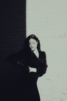 Striking black and white portrait of a woman in dramatic light and shadow.