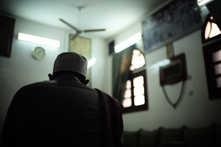 Man In Traditional Headwear Sitting In Room