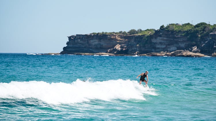 A Man Surfing On The Sea  