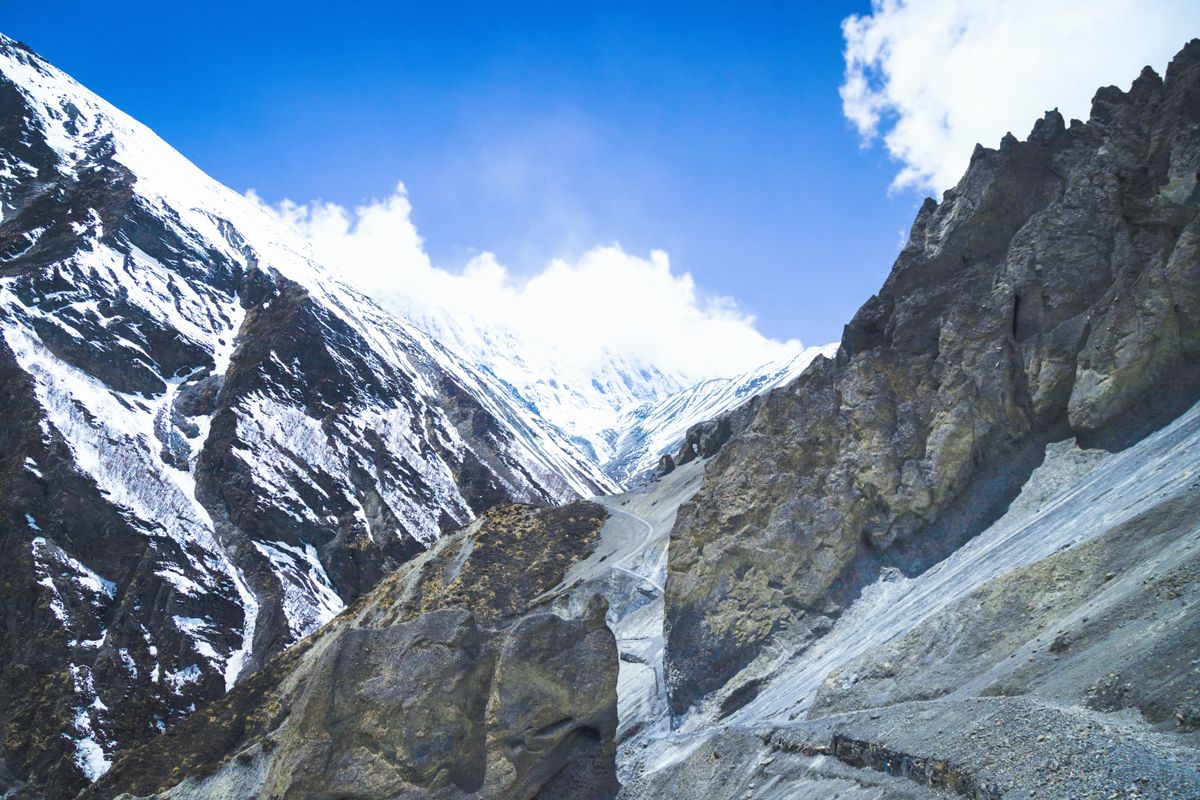 Breathtaking view of snow-capped peaks in Manang, Nepal, under a clear blue sky.