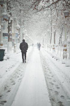 A serene winter scene with people walking on a snowy street in Malatya.