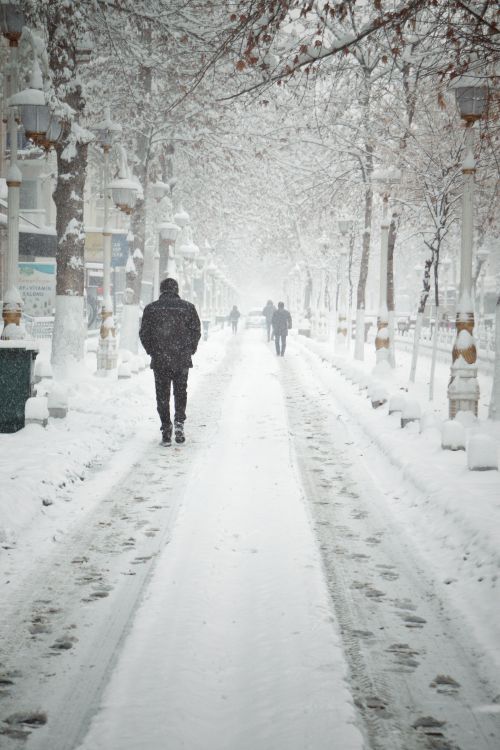 Free A serene winter scene with people walking on a snowy street in Malatya. Stock Photo
