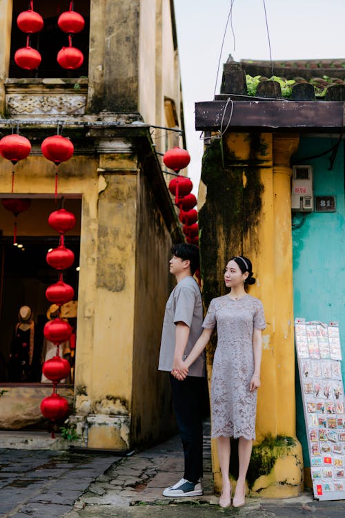 Couple Holding Hands Standing on Street Decorated with Red Lanterns