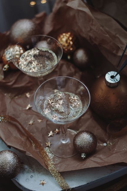 Top view of champagne flutes with star decorations and ornaments, perfect for holiday celebrations.