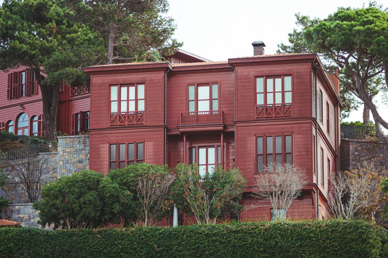 A picturesque red house surrounded by greenery in an urban setting in Istanbul, Turkey.