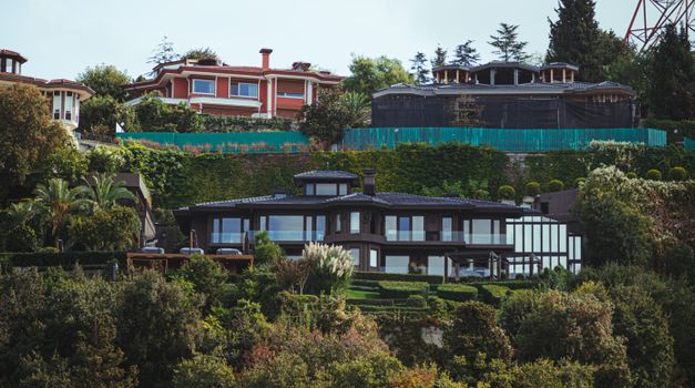 Stunning view of luxurious mansions surrounded by lush vegetation with a modern architectural design.