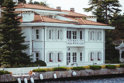 Charming white mansion with red rooftop and shutters by the Bosphorus in Istanbul, Turkey.