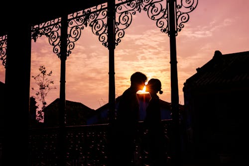 Free Silhouette of Couple Facing Each Other Against the Sunset Stock Photo