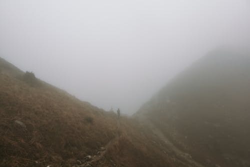 Silhouette of Person on Trail in Misty Mountains