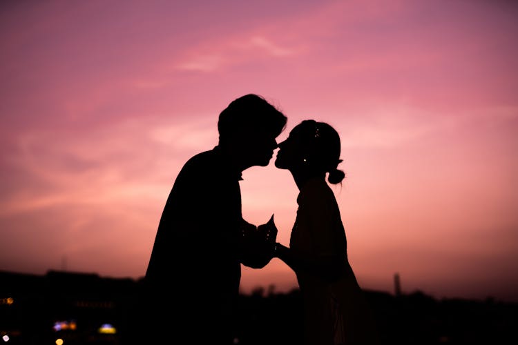 Silhouette Of Couple Kissing At Sunset