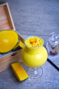 Delicious mango smoothie with saffron garnish, perfect for a healthy summer refreshment.