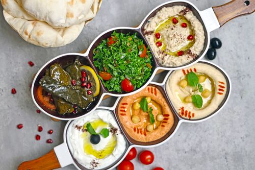 Free Delightful Middle Eastern mezze platter featuring hummus, baba ganoush, and fresh tabbouleh. Stock Photo
