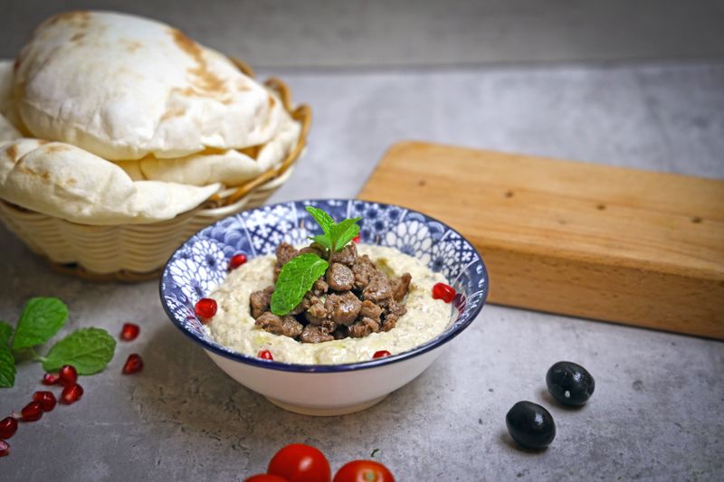 hummus bowl topped with olives and cucumber