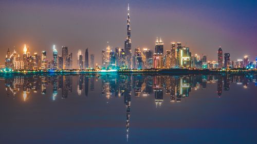 Free Captivating night skyline of Dubai with city lights reflecting in calm waters. Stock Photo