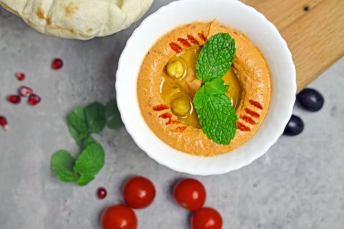 Free Creamy hummus with olive oil and mint, served with pita, cherry tomatoes, and olives. Stock Photo