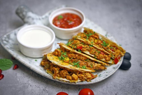 A plate with tacos and salsa on it