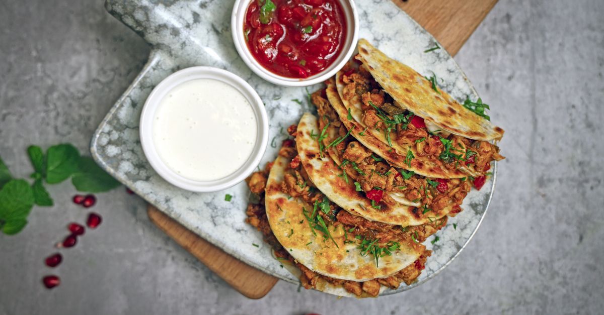 close-up of shredded jackfruit in a tortilla with salsa and cilantro, overhead shot
