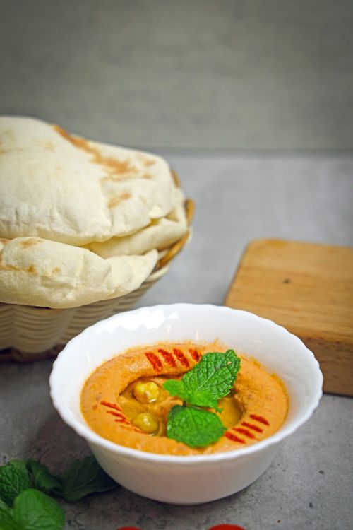 Free Delicious Middle Eastern hummus with pita bread garnished with mint leaves. Stock Photo