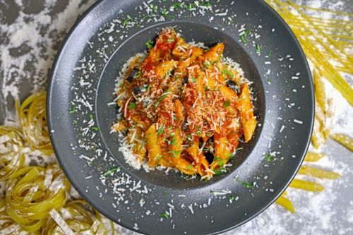 Free Tasty penne pasta in rich tomato sauce topped with Parmesan cheese and herbs. Stock Photo
