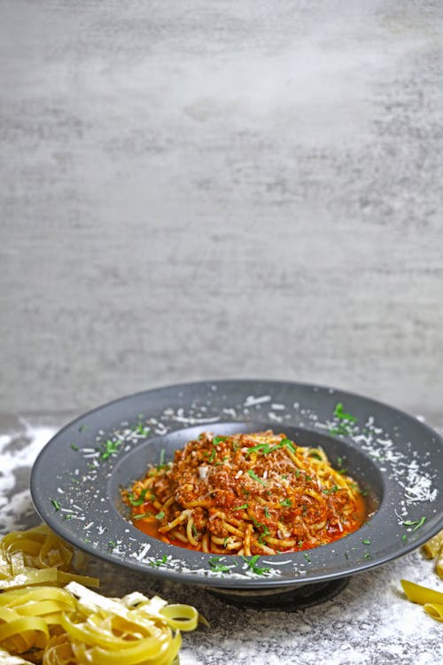 A plate of spaghetti with meat and cheese