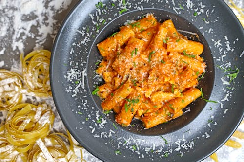 A plate of pasta with sauce and parmesan cheese